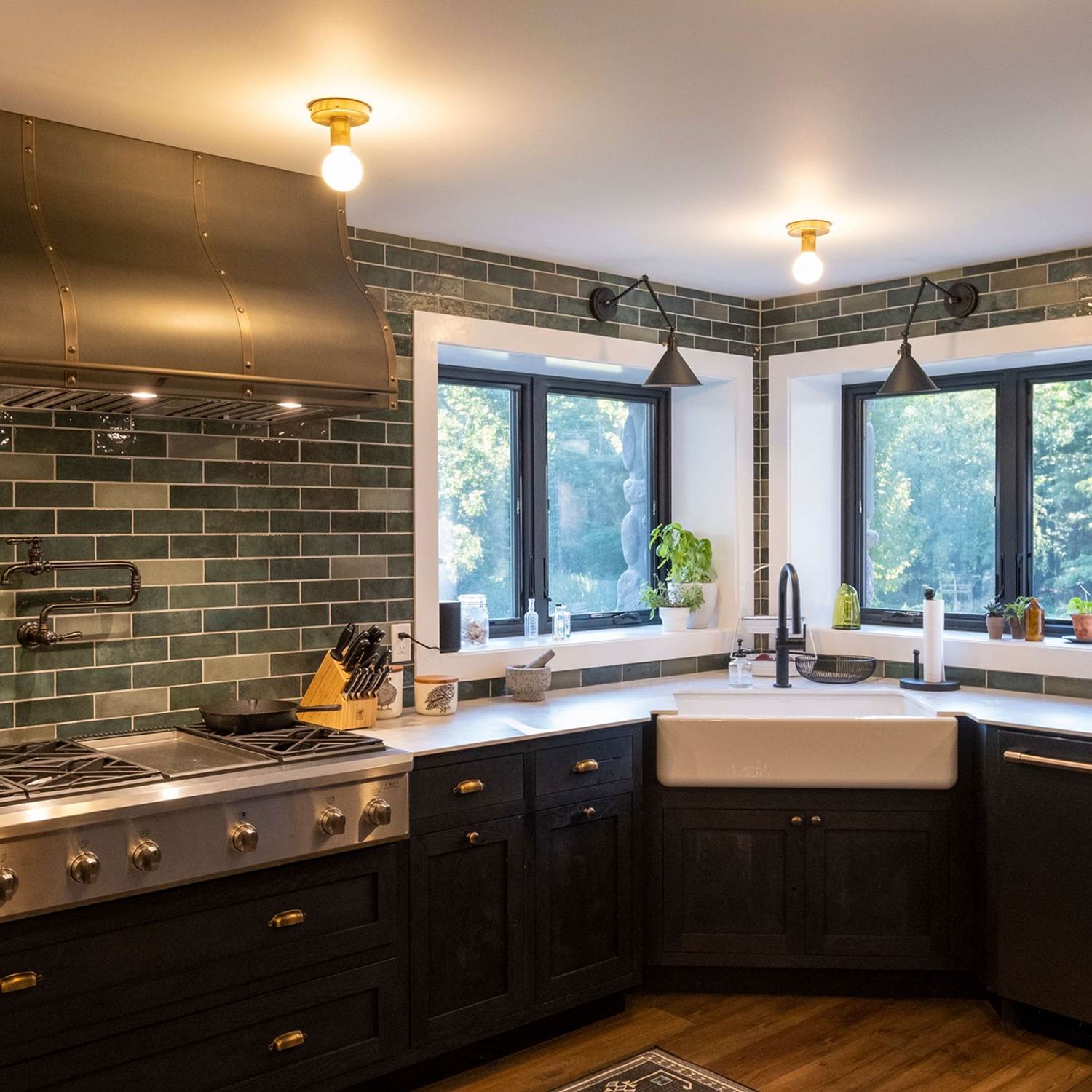 Subway tile kitchen with black cupboards, a wood floor, and black casement windows above the sink.