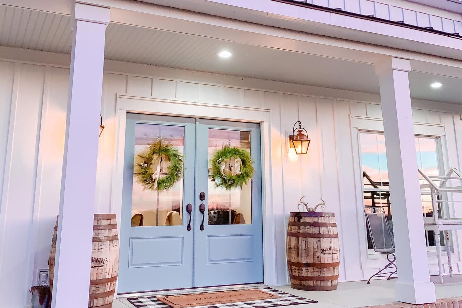 Light blue double entry door surrounded by white siding.
