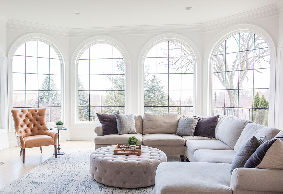 Living room shot with new REnewal by ANdersen windows in the arched manor. Black modified colonial  grilles