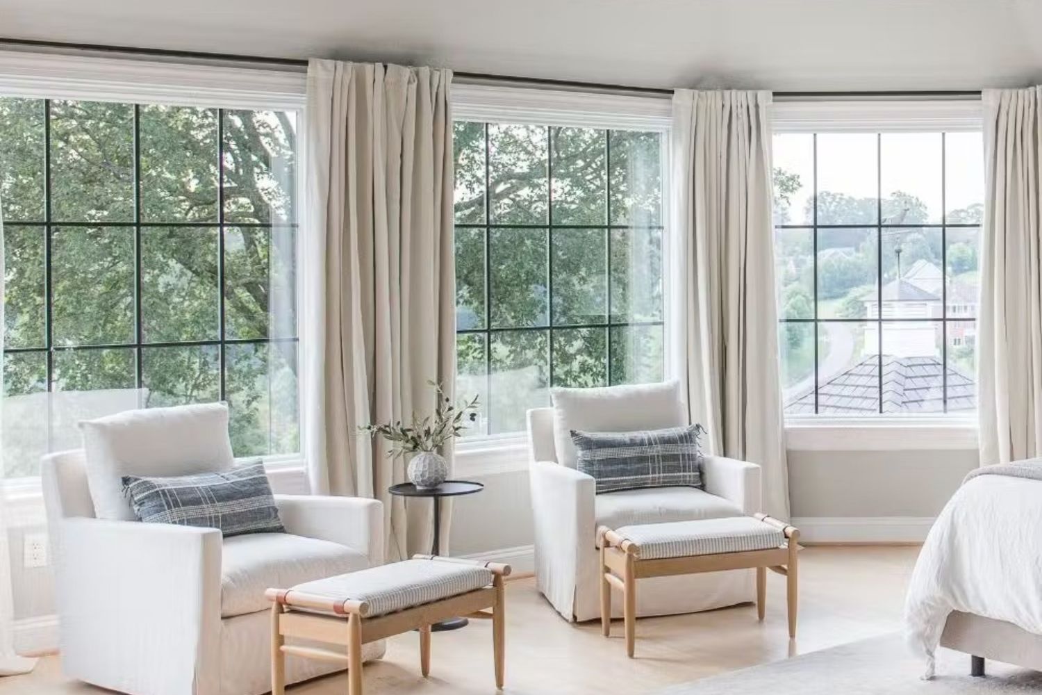 after remodel of kaplar bedroom. White walls, white windows with black grills, and white furniture with wood accents.