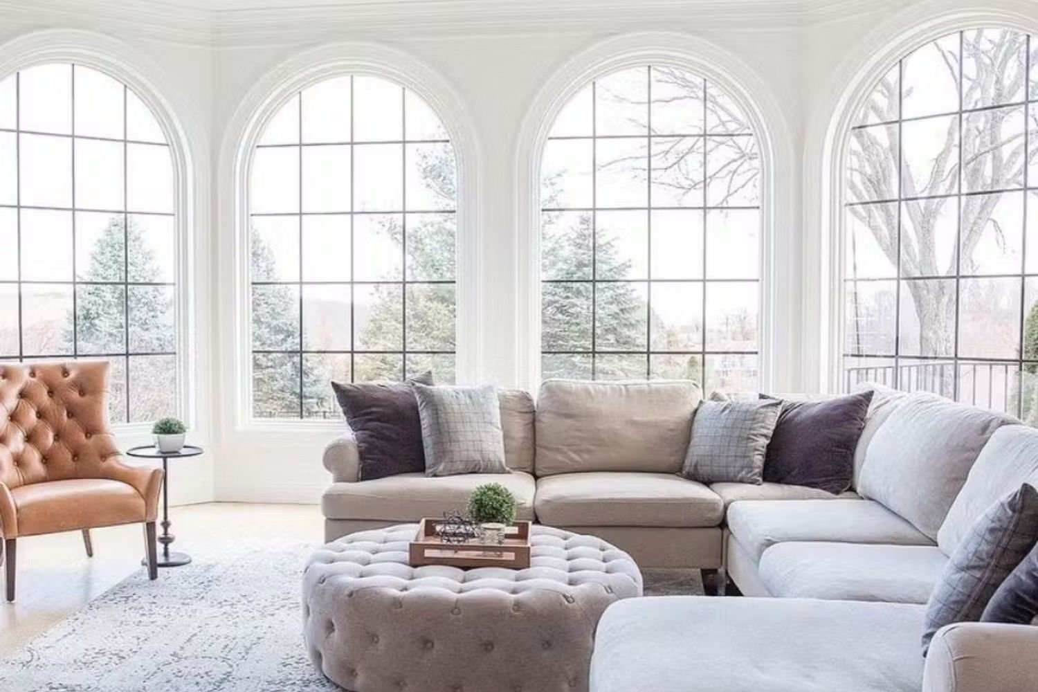 After living room remodel showing white walls, white windows with black grills, light furniture and light flooring.
