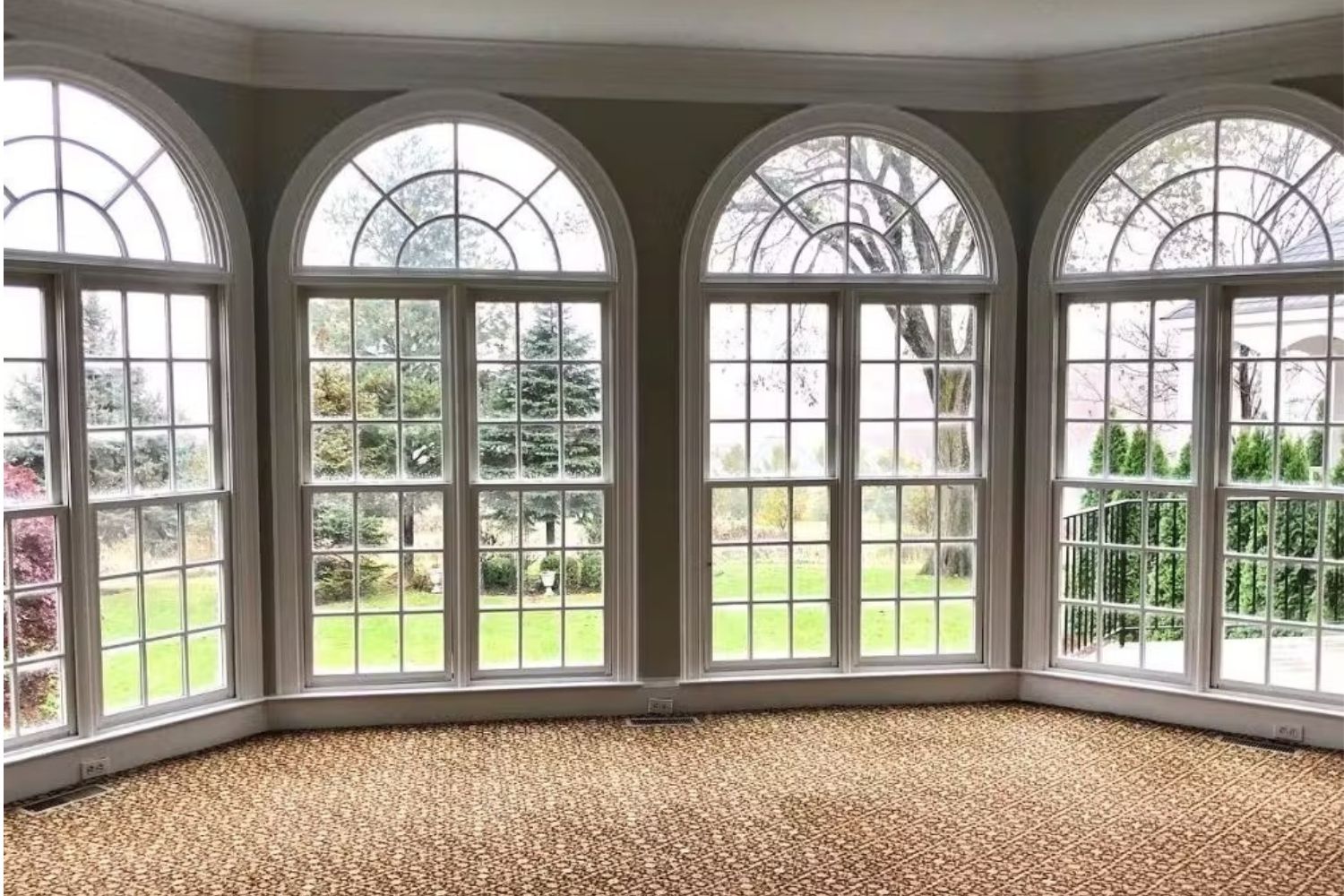 Before living room remodel showing brown carpet, and old double hung windows.