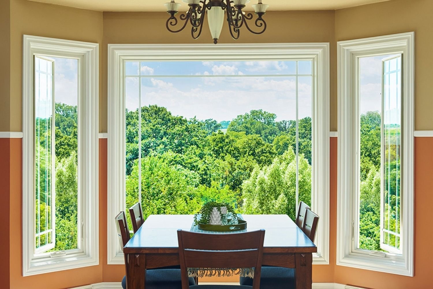 Bay window configuration with a picture window in the middle and casement windows on either side in the eating area of a kitchen.