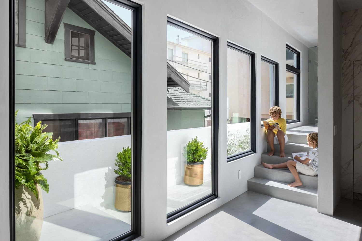 A beautiful interior shot of a family playing around, with large windows looking out to the patio