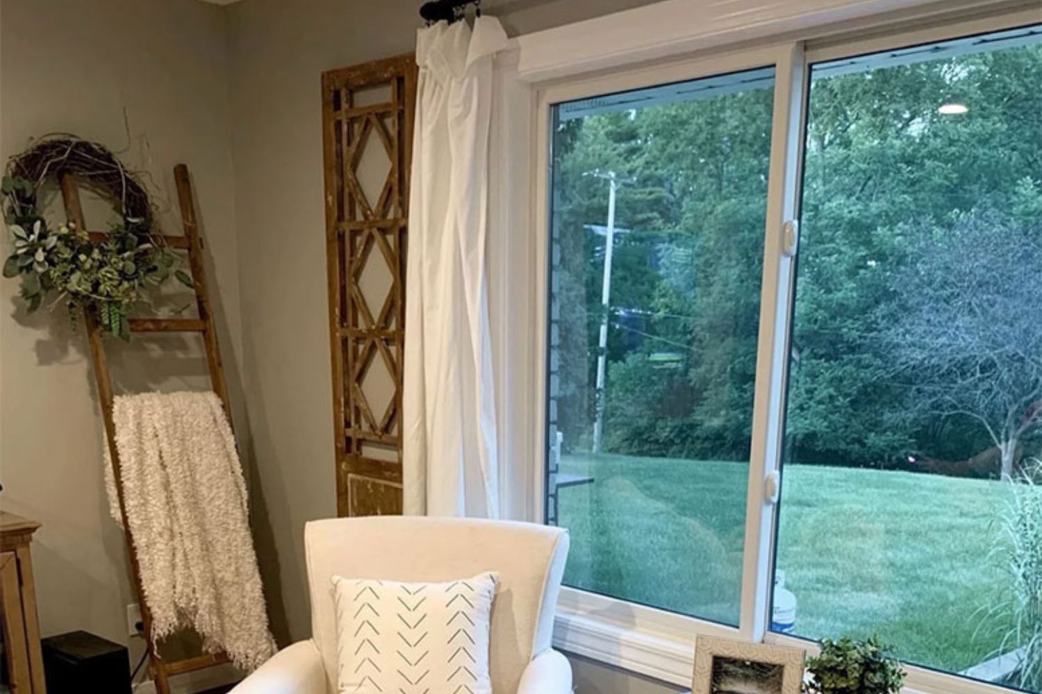 Gray living room with a white plush chair in front of a white sliding window.