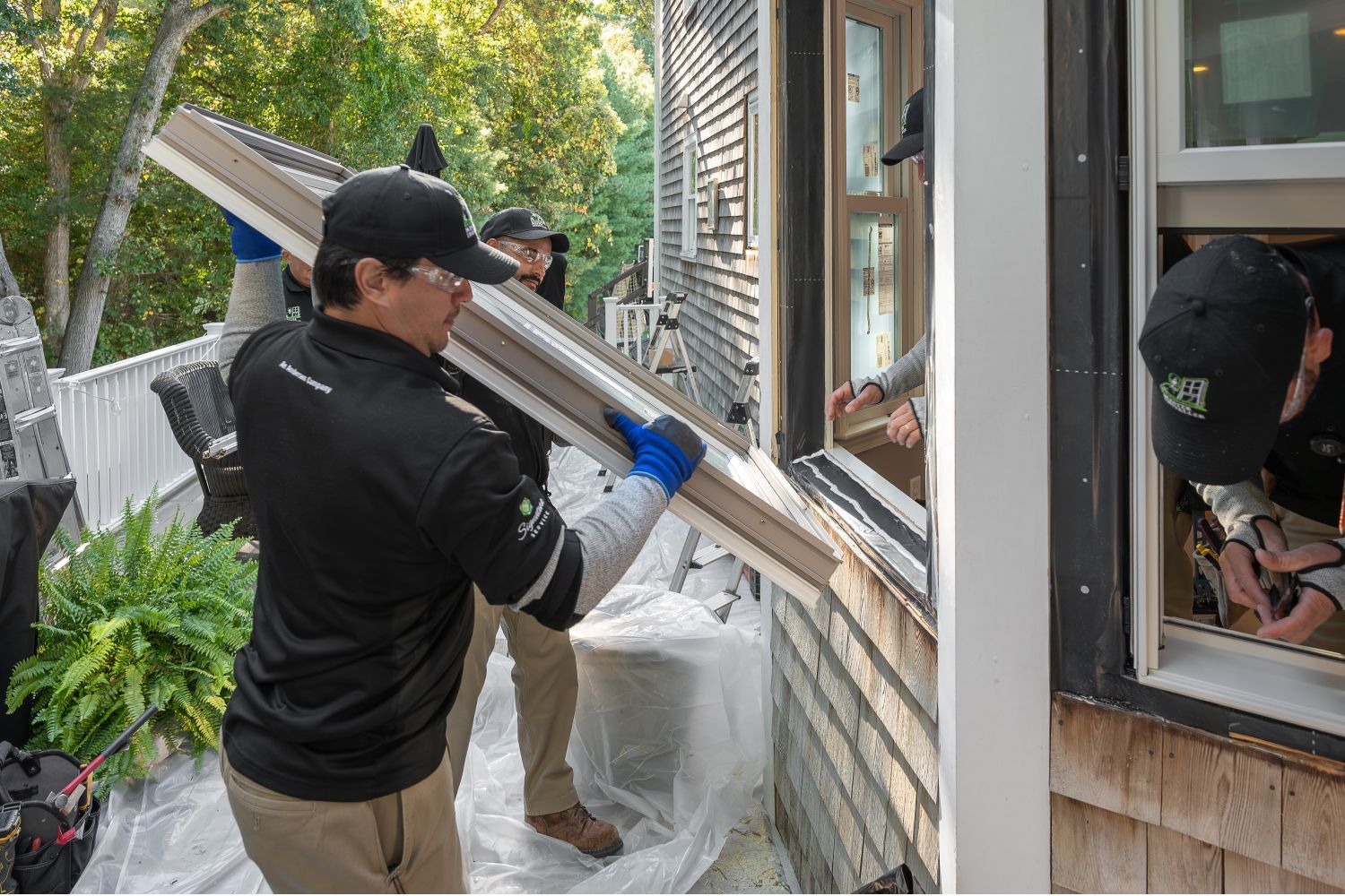Two men are collaborating to install or repair a window in a residential setting.