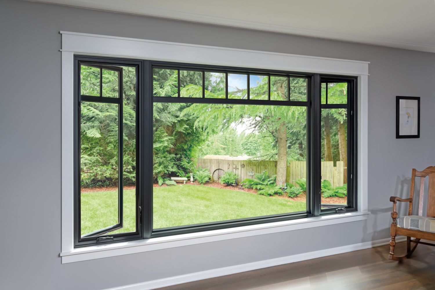 A large window illuminates a room featuring a chair and a table, creating a cozy and inviting atmosphere.