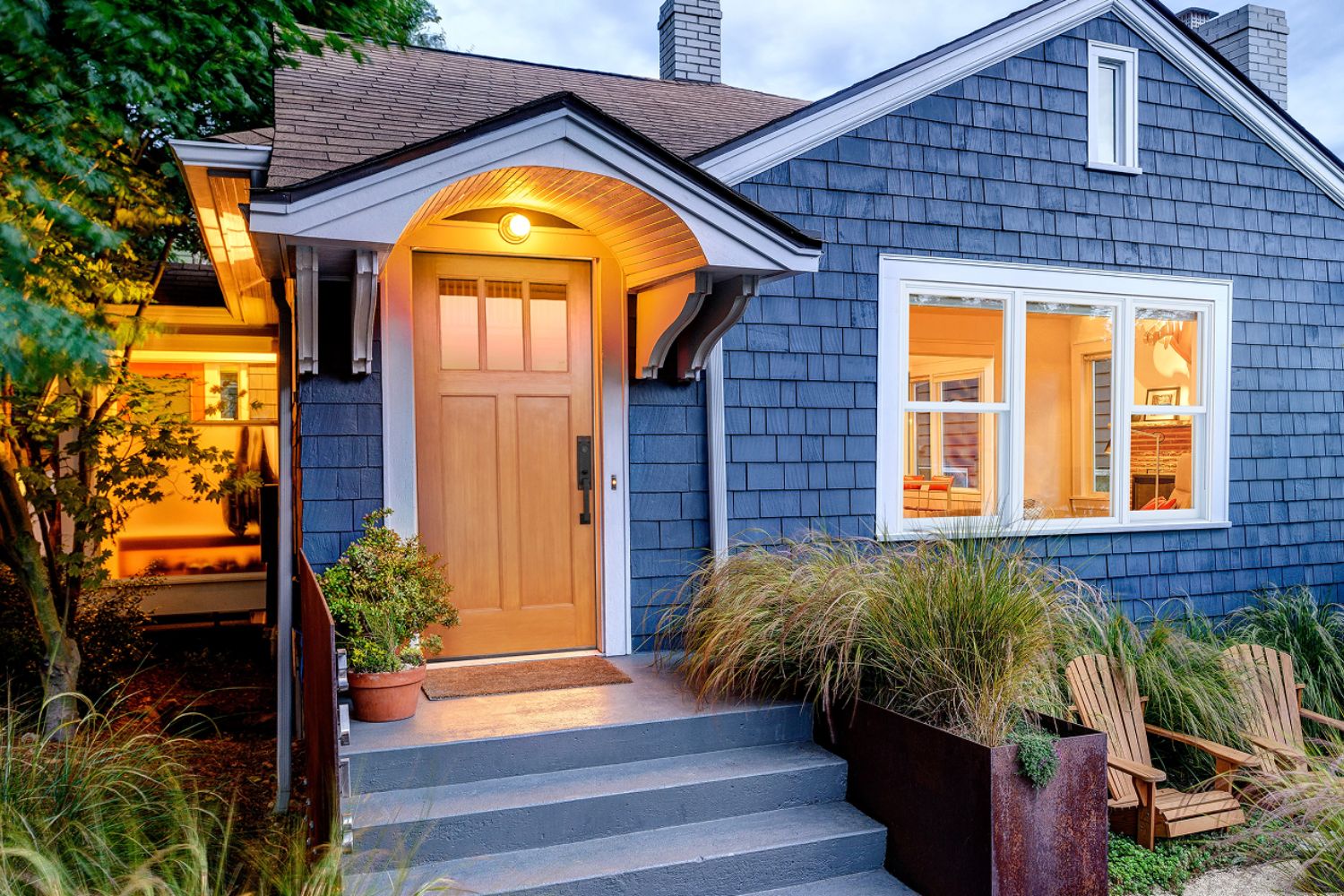beautiful blue sided house with a wood front entry door.