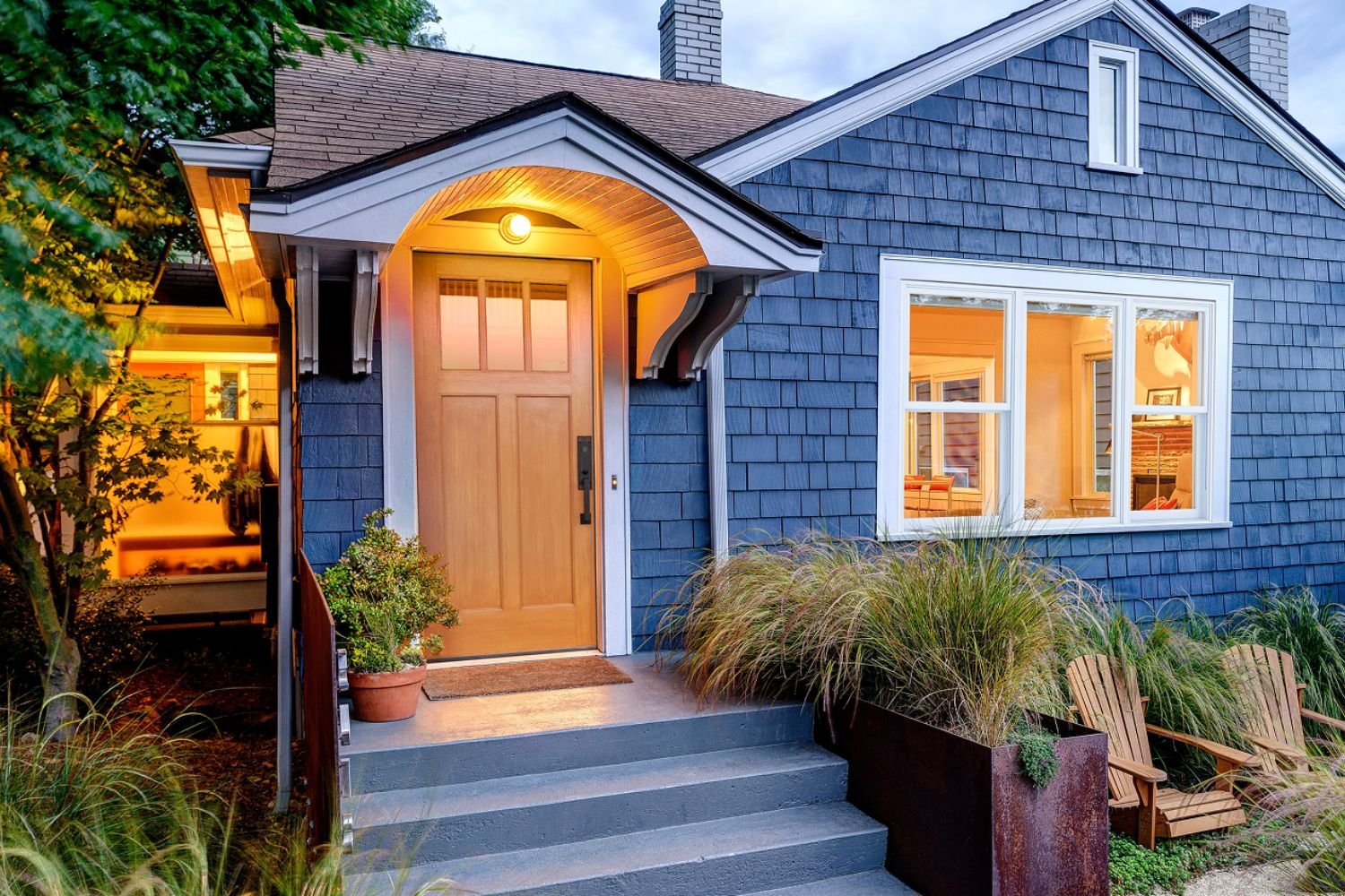 beautiful blue sided house with a wood front entry door.