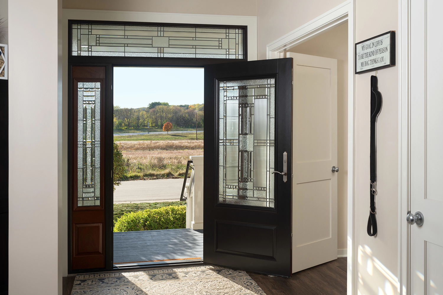 Interior view of a black entry door with a glass pane in it.