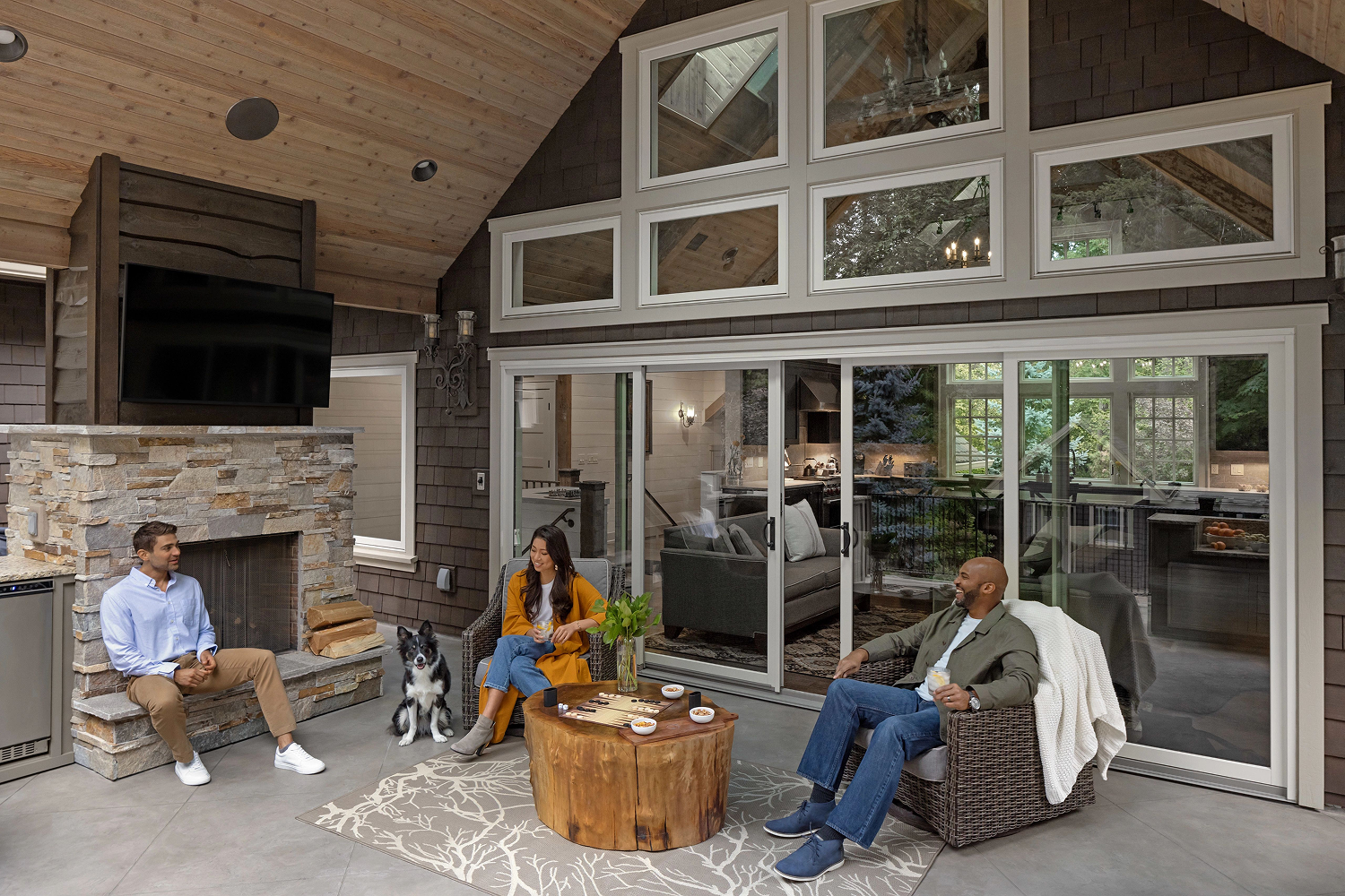 Exterior view of a patio door in the back of a house. A family is sitting, enoying the patio.