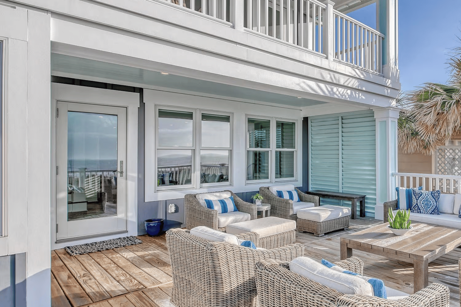 Exterior view of a patio on a blue beach home that has Renewal by Andersen Acclaim Impact windows