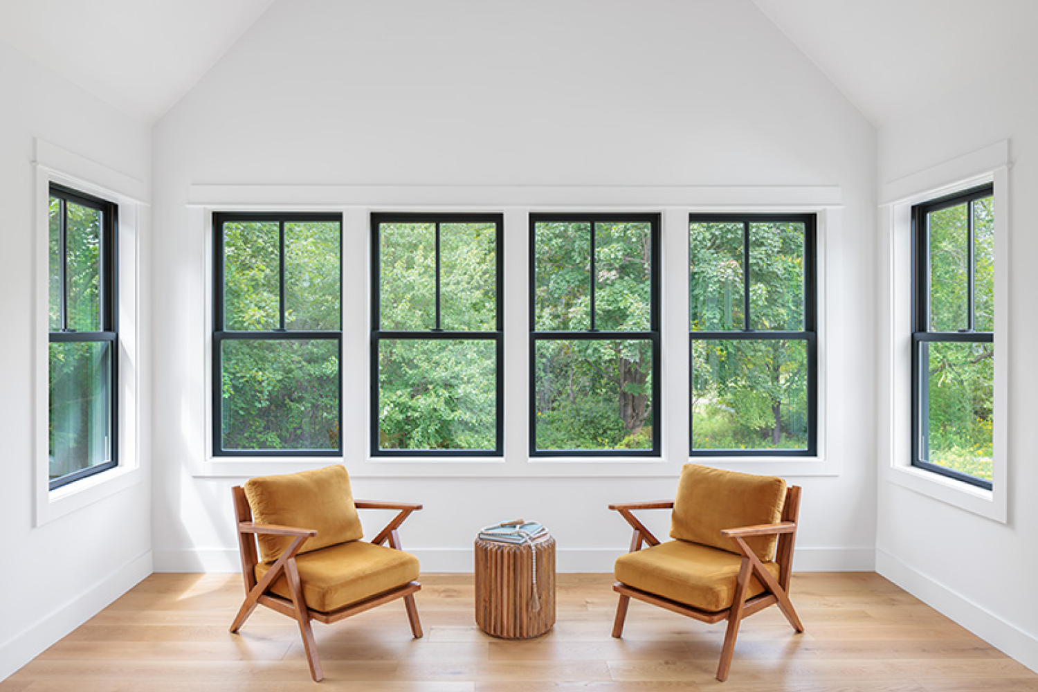 Two chairs arranged before Renewal by Andersen's Composite Windows, showcasing a bright and welcoming interior setting.