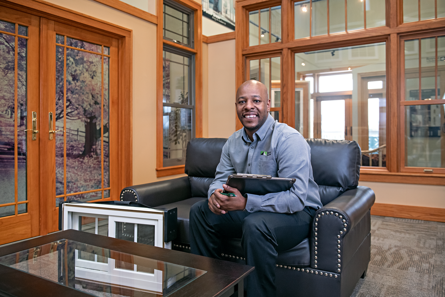 A Renewal by Andersen design consultant sitting in a couch at one of renewal by andersen's showrooms