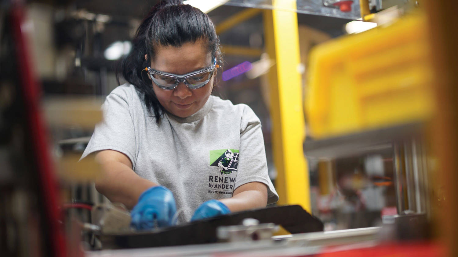 A Renewal by Andersen installer crafting a custom window in the warehouse