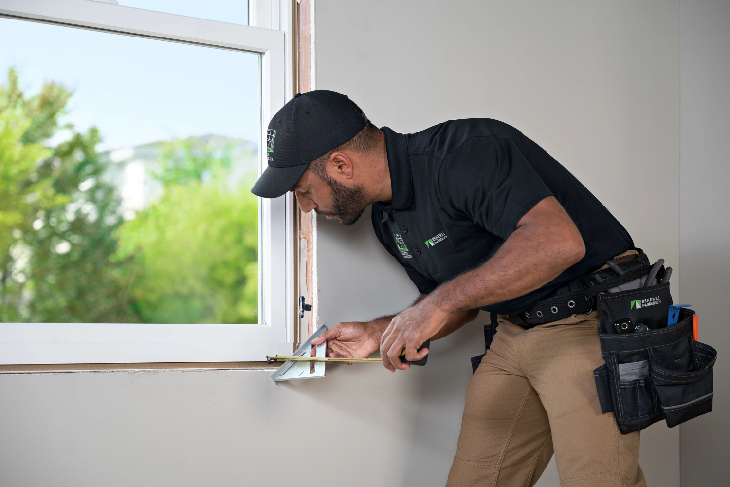 Renewal by Andersen installer measuring windows for homeowners