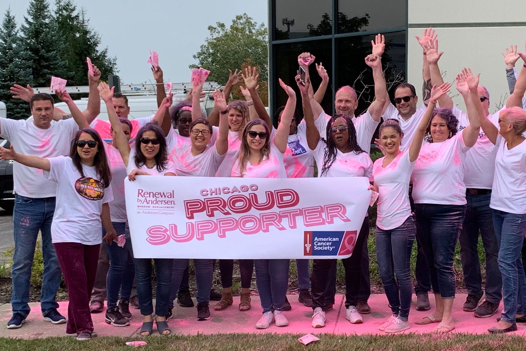 Group of RbA employees covered in pink chalk during an ACS event.