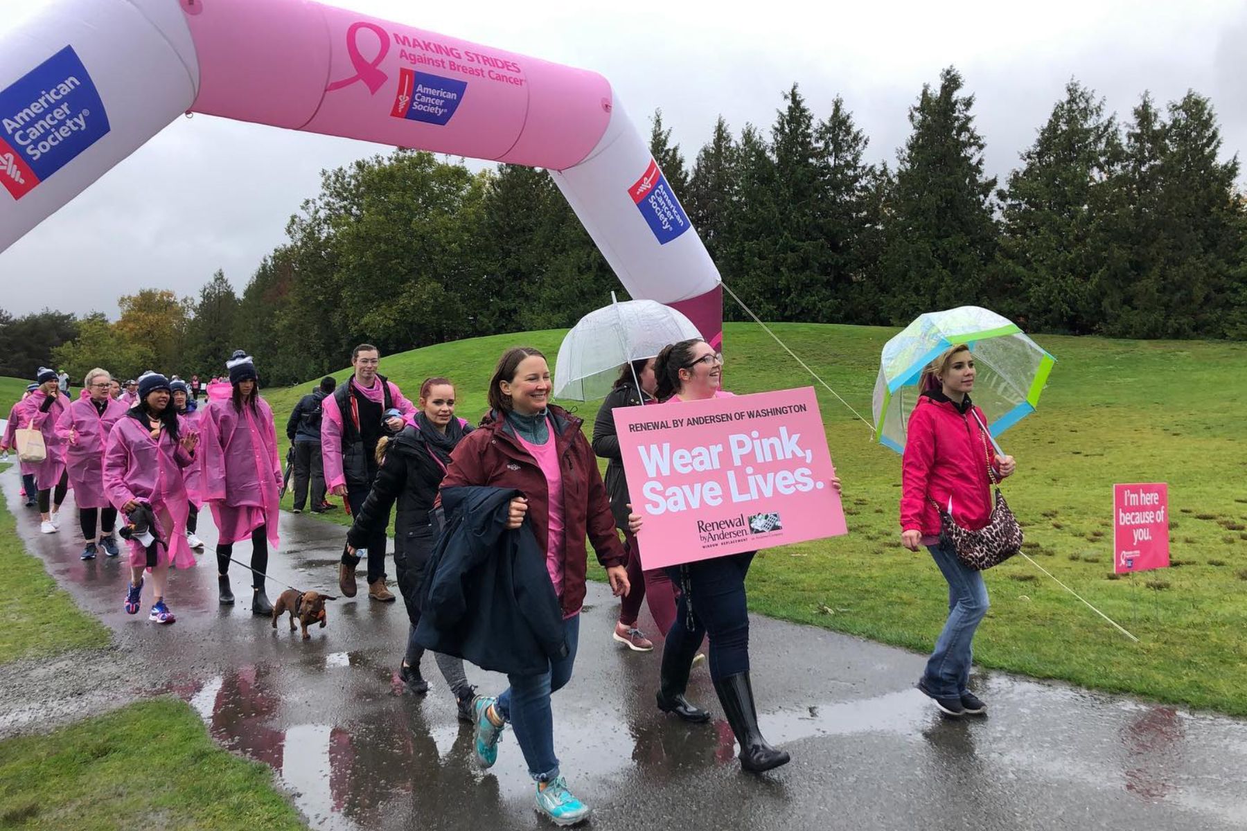 Group of RbA employees wearing pink shirts during Wear Pink, Save Lives walk in the rain. 