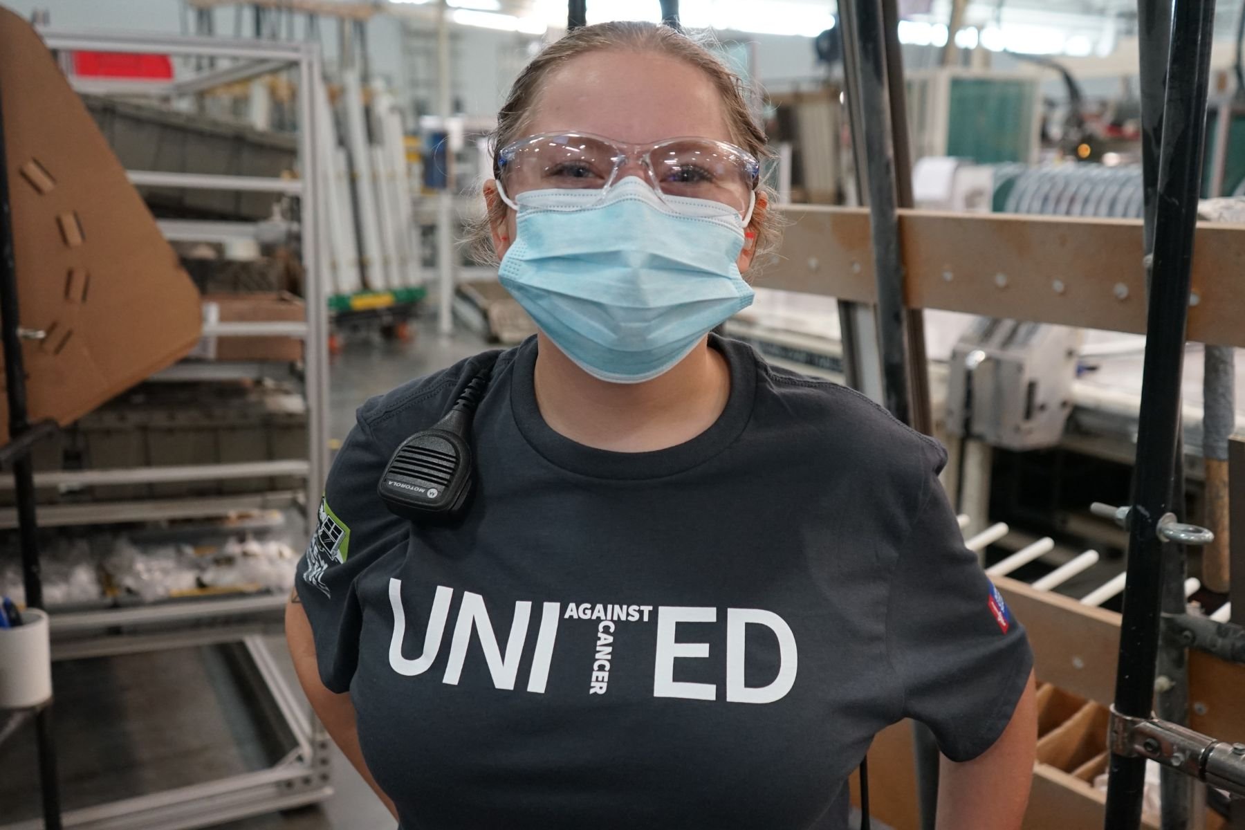 Portrait of RbA manufacturing employee wearing a mask and a United Against Cancer t-shirt.