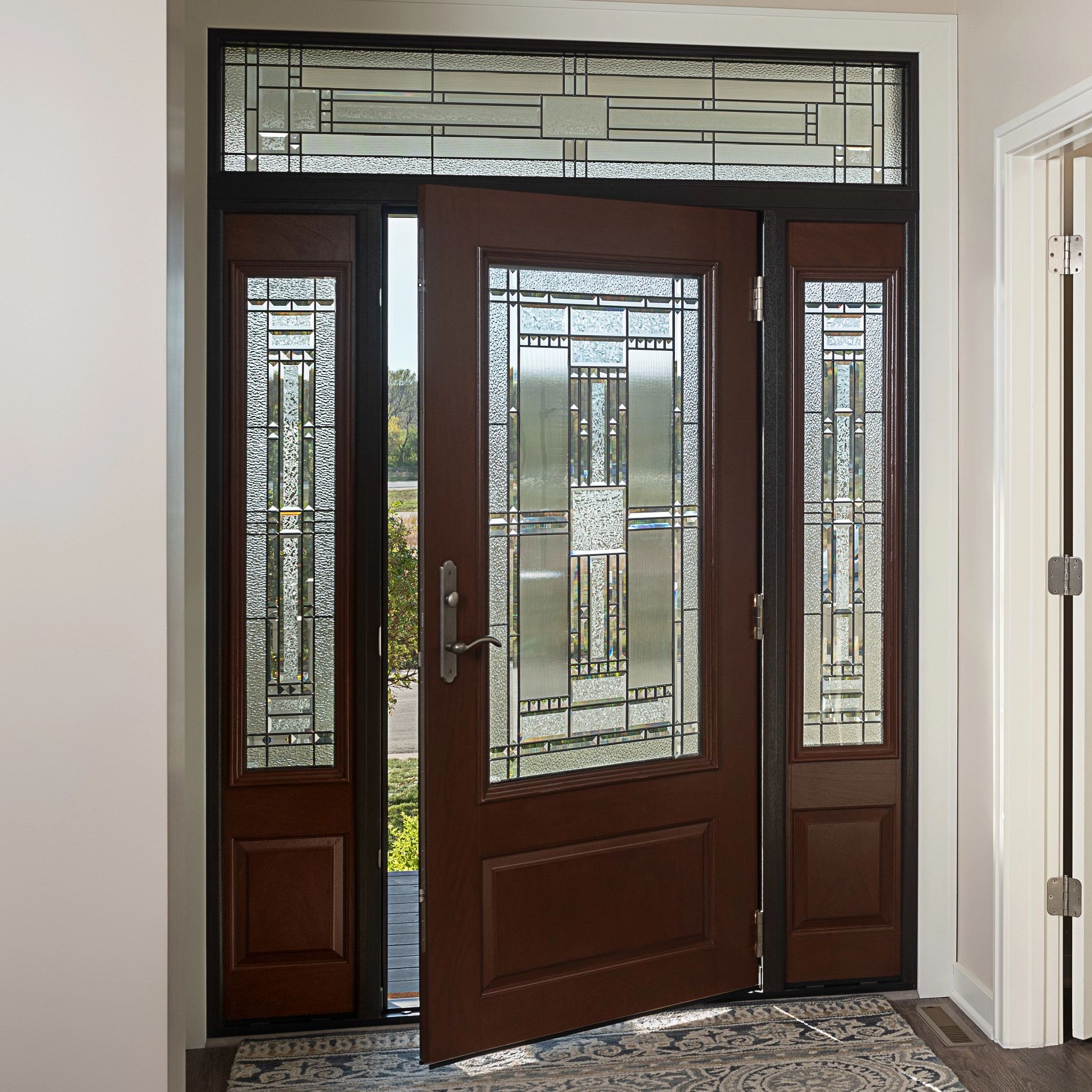 An Ensemble entry door with dual sidelights viewed from inside. The door has craftsman art glass and a wood finish.