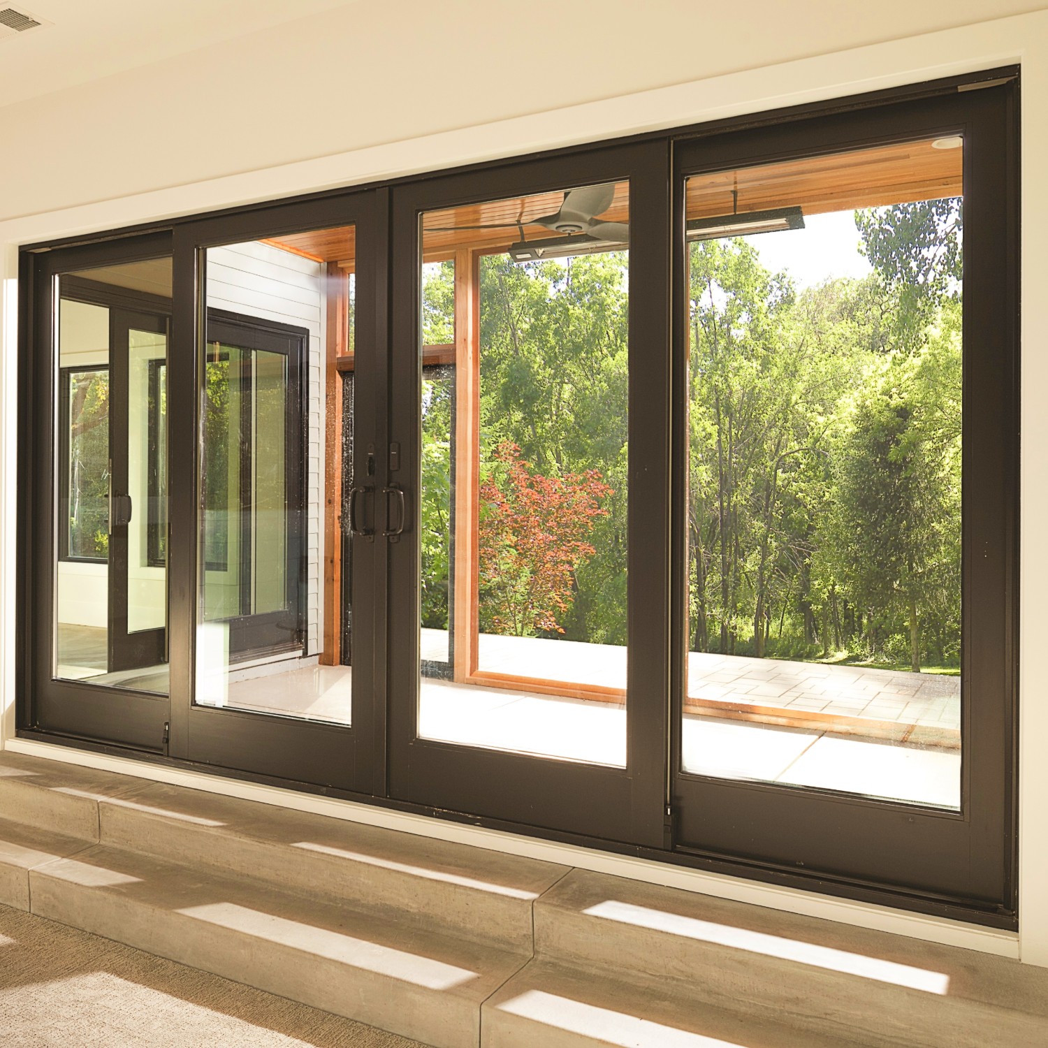 A bank of four traditional A-series doors in black. Two are sliding patio doors.