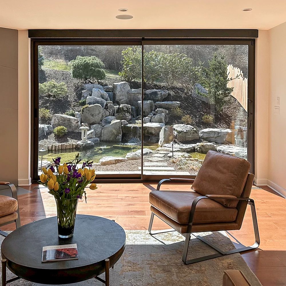 A view out of a multipanel sliding door to a landscaped yard.
