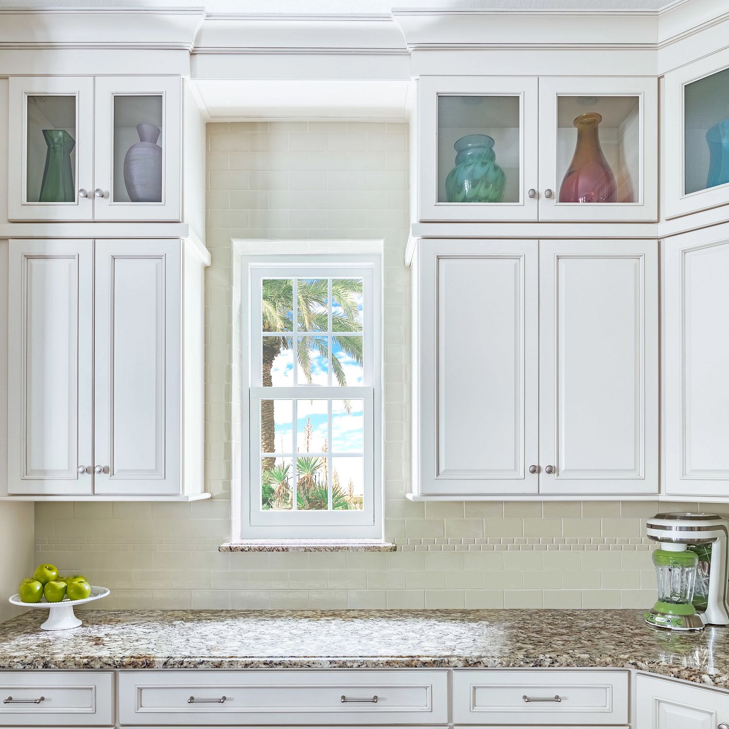A small kitchen window between cabinets.