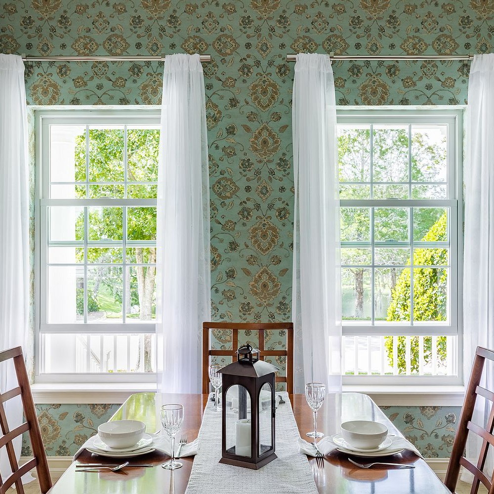 a pair of white double hung windows with colonial grilles in a dining room