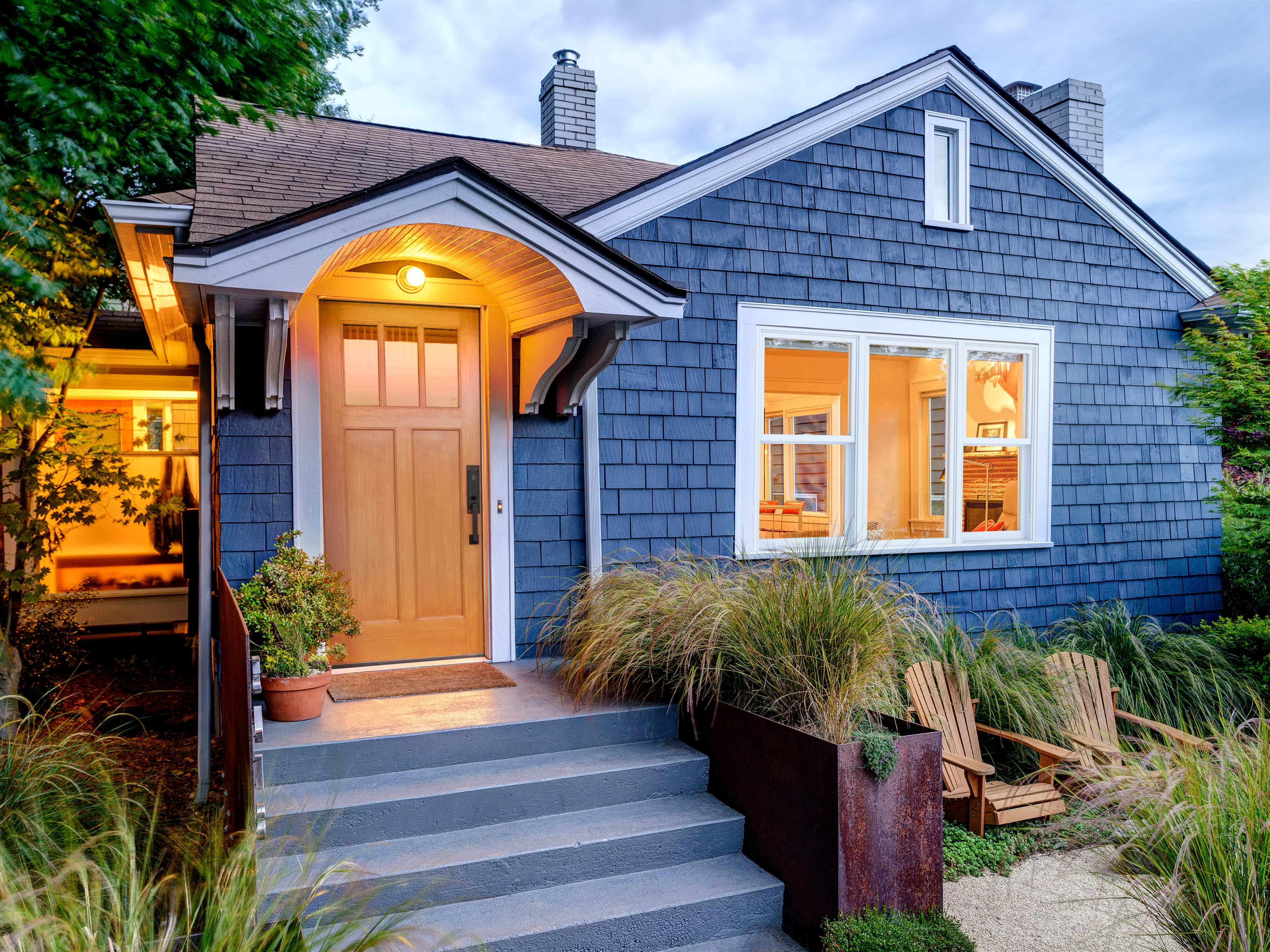 Exterior of a blue house with double hung windows from RbA